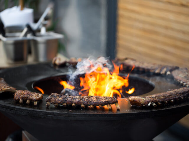 Grilled pork baby ribs with barbecue sauce on the grill. Festival street food